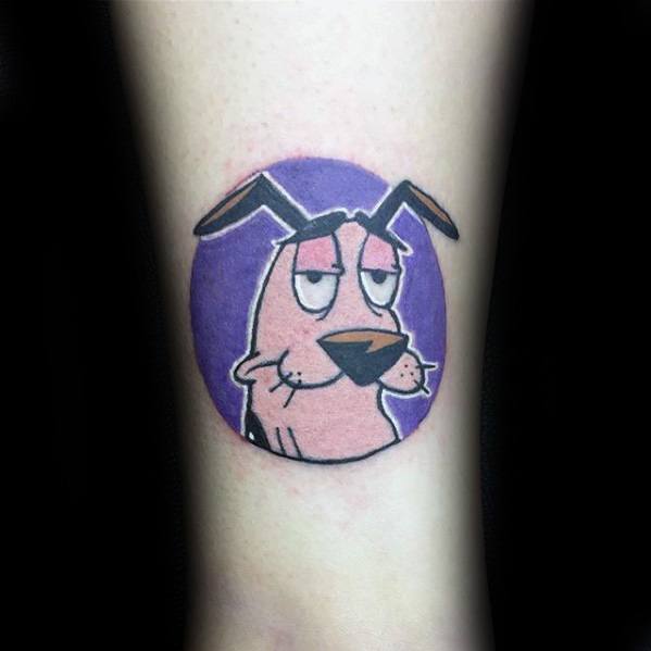 Minimalist tattoo of Courage the Cowardly Dog with a bored expression, set inside a purple circle on the forearm.