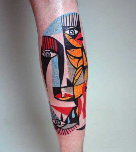 Colorful Cubist tattoo on the calf featuring abstract faces, eyes, and teardrops in bold red, yellow, blue, and black shapes.