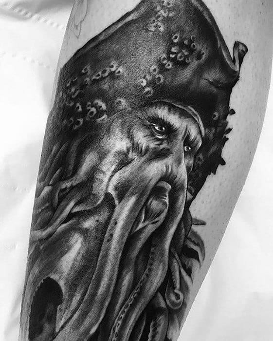 Tattoo of a bearded character with a detailed, Davy Jones-inspired headpiece