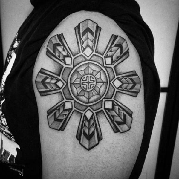Black and grey geometric tattoo of an intricate circular design on an upper arm