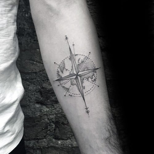 Minimalist compass tattoo on forearm with dotted globe background and fine line arrows, symbolizing travel and direction.