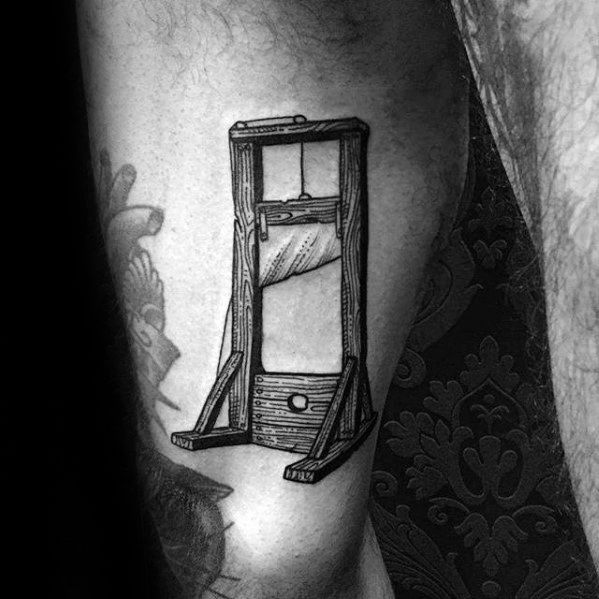 Fine line guillotine tattoo with detailed wood texture, raised blade, and minimalist shading for a classic monochrome look.