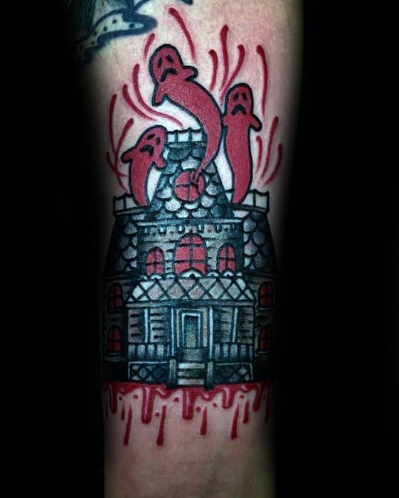 Colorful haunted house tattoo with cartoon ghosts rising from the roof and red dripping blood effect at the base.