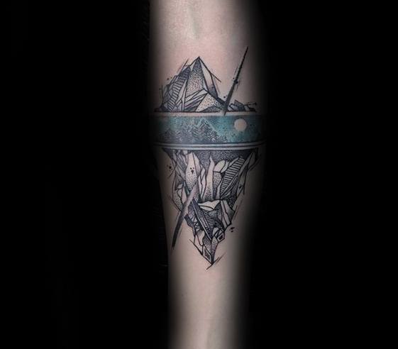 Artistic iceberg tattoo with turquoise waterline, abstract underwater details, and boats floating above the jagged surface.