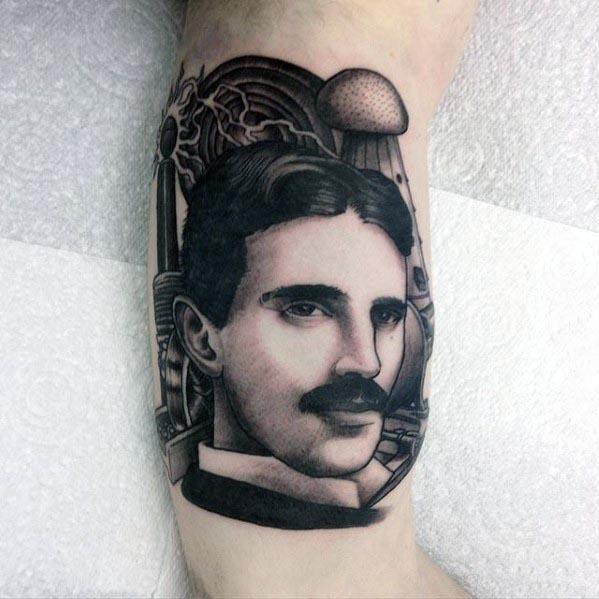 Detailed black and grey portrait tattoo of Nikola Tesla surrounded by gears, coils, and vintage electrical components.