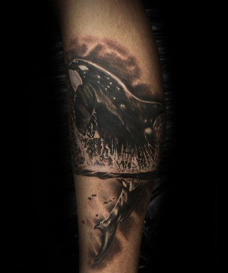 Detailed black and gray orca tattoo design on the forearm, depicting the whale leaping out of the water.