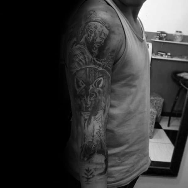 Man with a sleeve tattoo featuring a bearded warrior and a wolf on his right arm