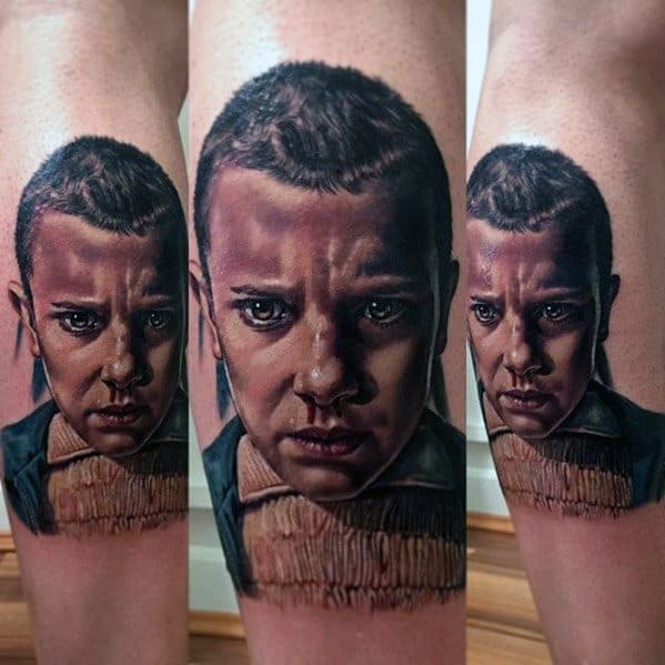 Hyper-realistic tattoo of Eleven from Stranger Things with a focused expression, detailed shading, and her signature buzzcut look.
