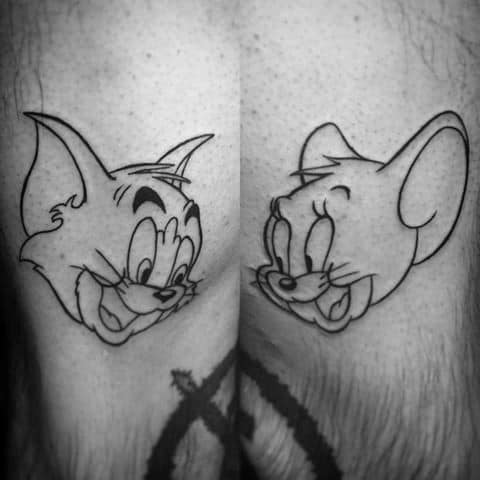 Minimalist black outline tattoo of Tom and Jerry smiling at each other, inked on the back of both thighs.