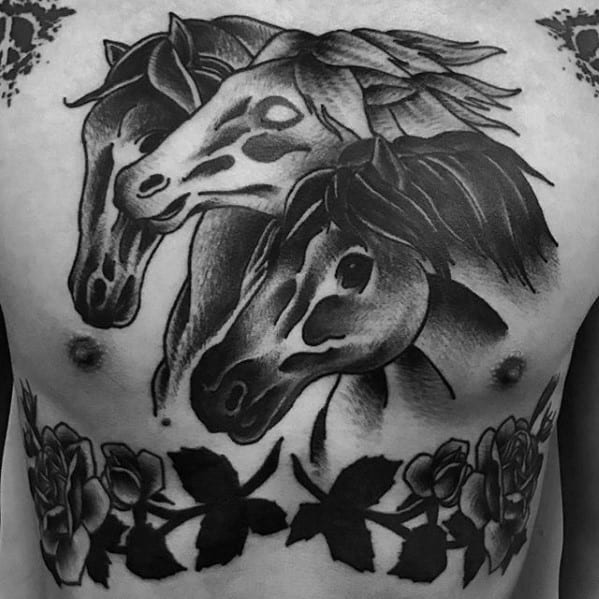 Black and grey chest tattoo featuring three detailed horse heads above a row of roses and leaves across the lower chest.