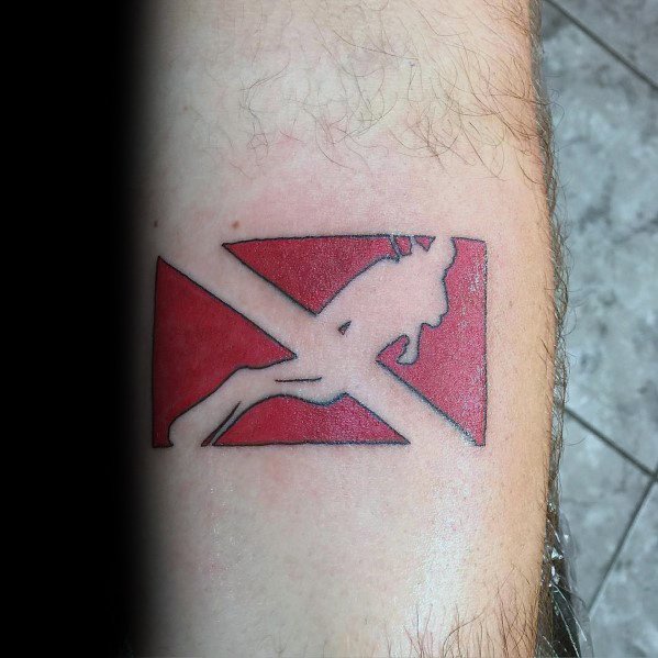 Tattoo of a red and white dive flag with a silhouetted scuba diver, symbolizing a passion for underwater exploration and the diving lifestyle.