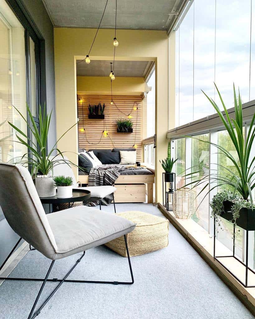 Modern balcony with cozy seating, string lights, potted plants, and a lounge area.