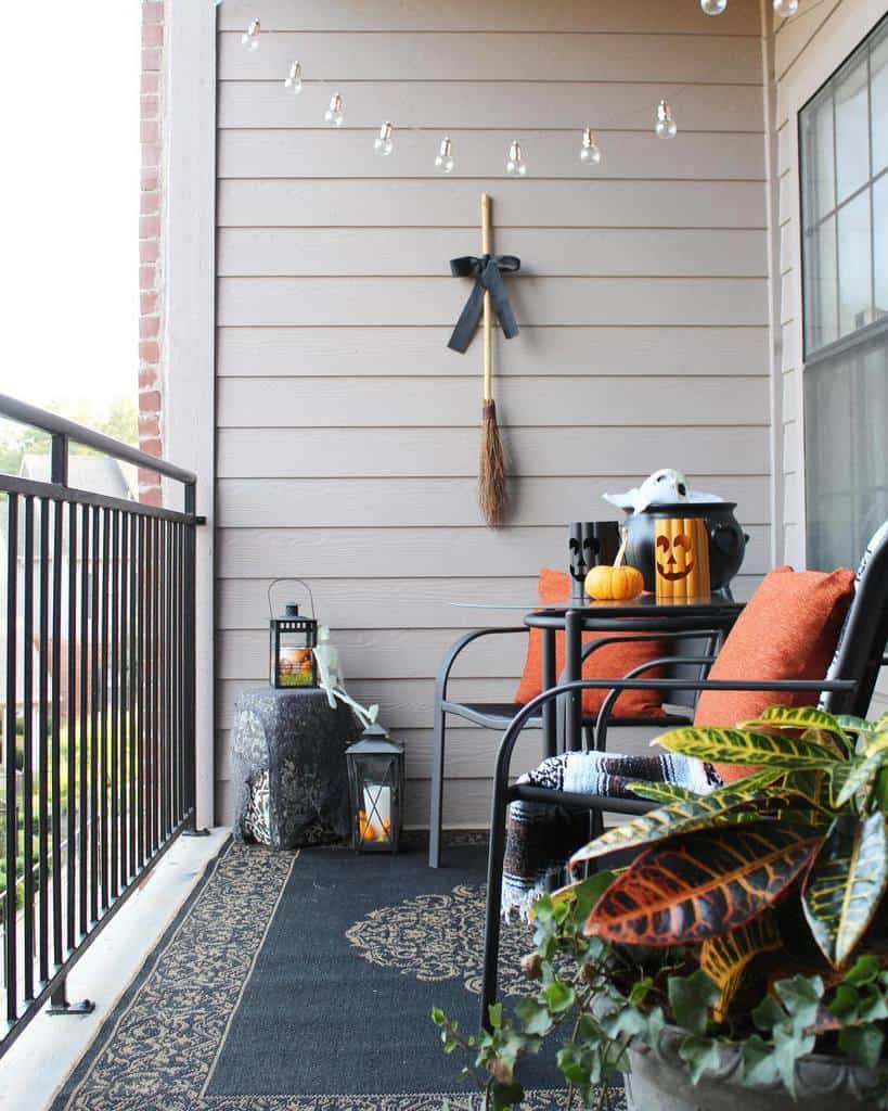 Cozy Halloween-themed balcony with pumpkins, lanterns, string lights, and a small seating area.