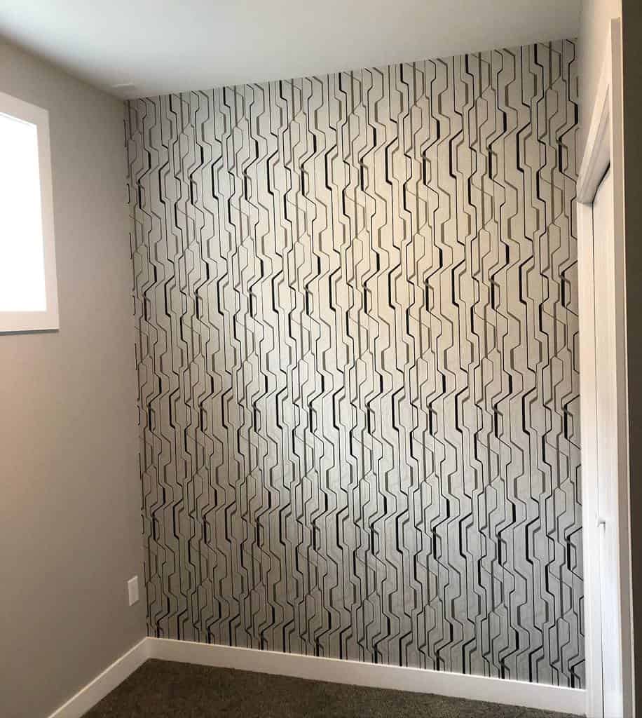 Modern basement wall with geometric patterned wallpaper and neutral surroundings.