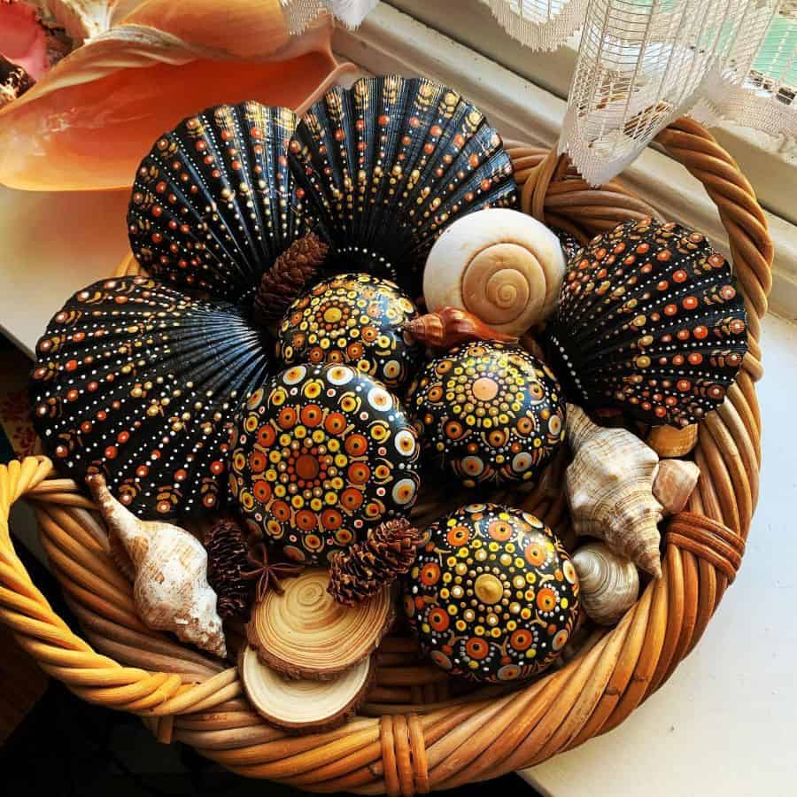 Decorative basket with hand-painted mandala stones, seashells, and pinecones.