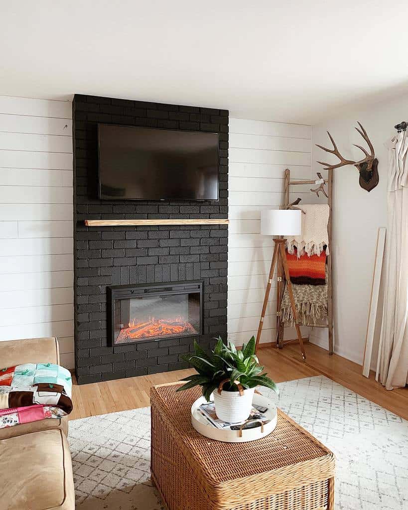 black brick fireplace white shiplap wall mounted tv decorative ladder deer horns wall art wicker chest