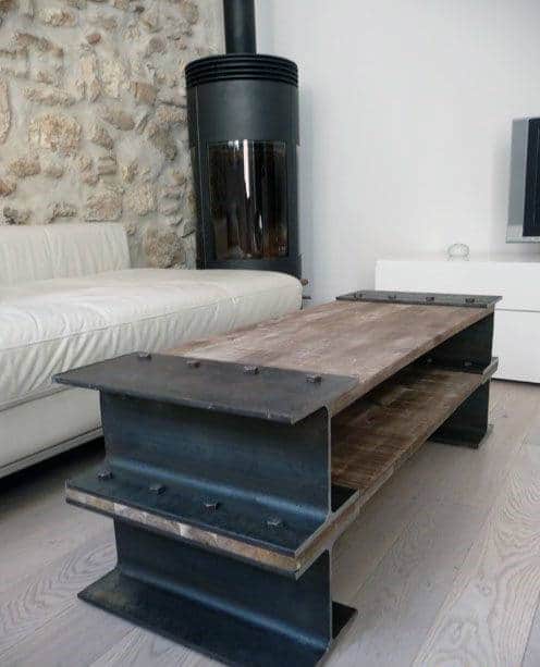 Industrial-style coffee table made of steel beams in a modern living room with a fireplace and white sofa