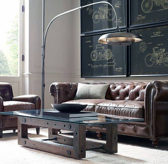 Stylish living room with leather sofas, glass coffee table, and framed blueprints on the wall