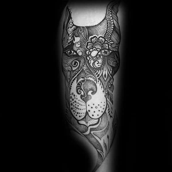 Intricate Doberman tattoo with floral and ornamental patterns, blending mandala and dotwork styles for a detailed and artistic design.