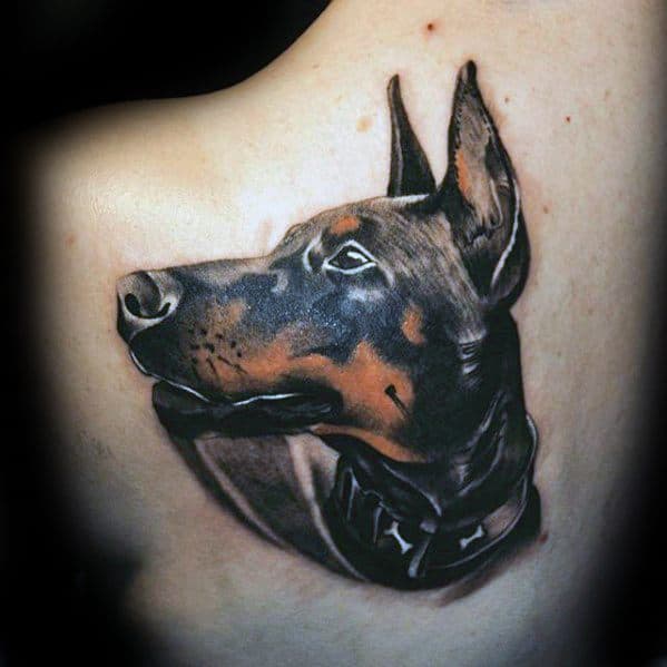Realistic Doberman tattoo with detailed shading and lifelike features, capturing the dog’s alert gaze and strong presence.