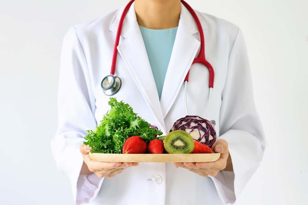 doctor holding fresh fruit and vegetable prescription for good health