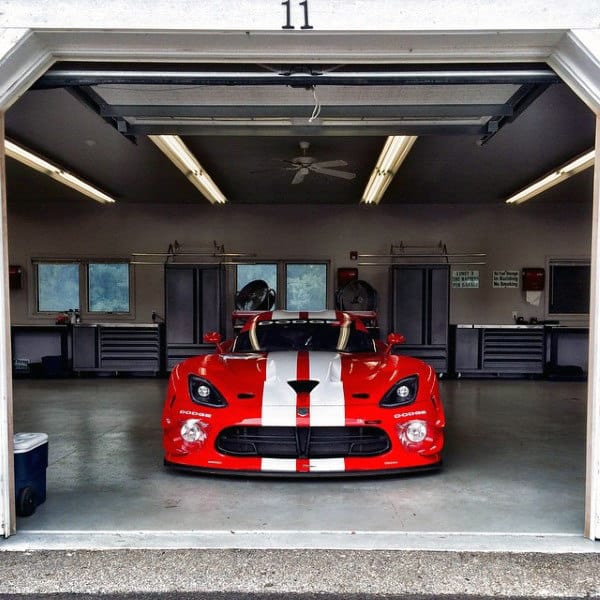 A sleek, well-organized garage featuring a striking Dodge Viper as the centerpiece.