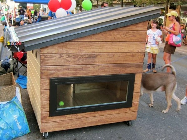 Modern wooden dog house with a slanted roof and large window
