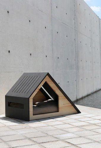Modern doghouse with a triangular design on a concrete patio