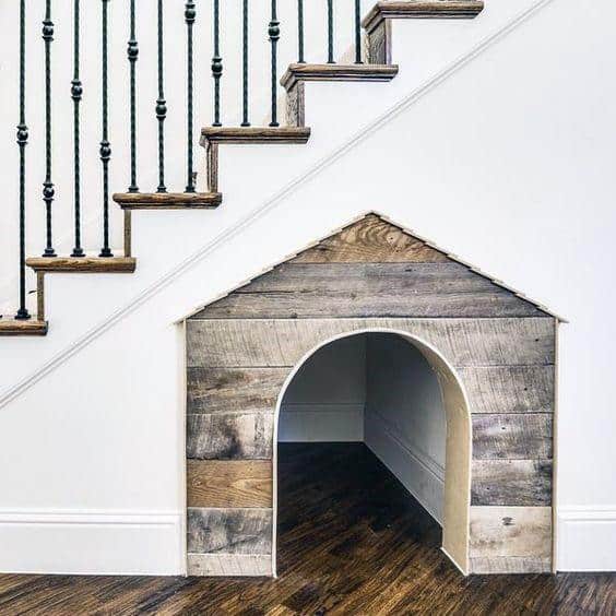 rustic wood dog house under the stairs 