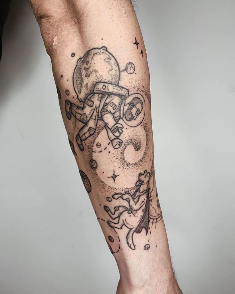Artistic forearm tattoo of an astronaut in zero gravity, with a lion appearing in a cosmic swirl.