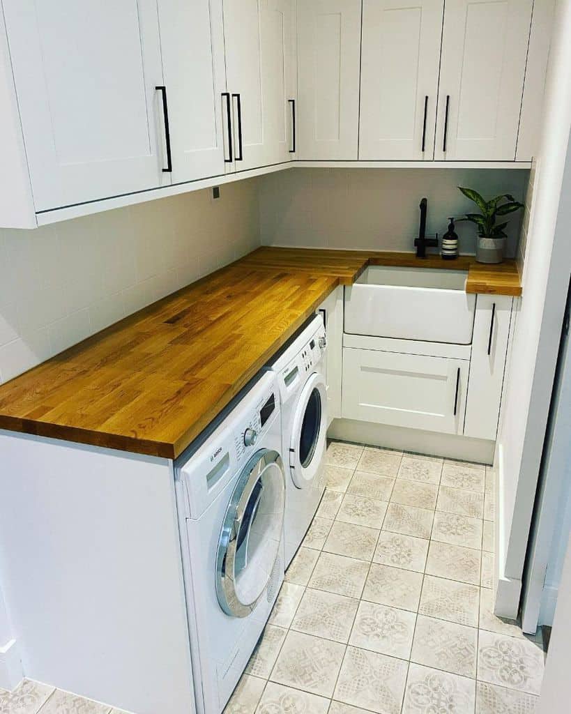 small laundry with glossy white cabinets apron sink and washer and dryer