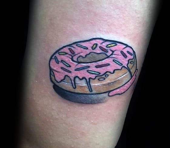 Tattoo of a pink frosted donut with colorful sprinkles and icing dripping down, casting a soft shadow for a 3D effect.