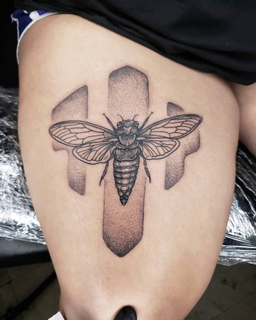 Detailed cicada tattoo on a thigh with abstract background