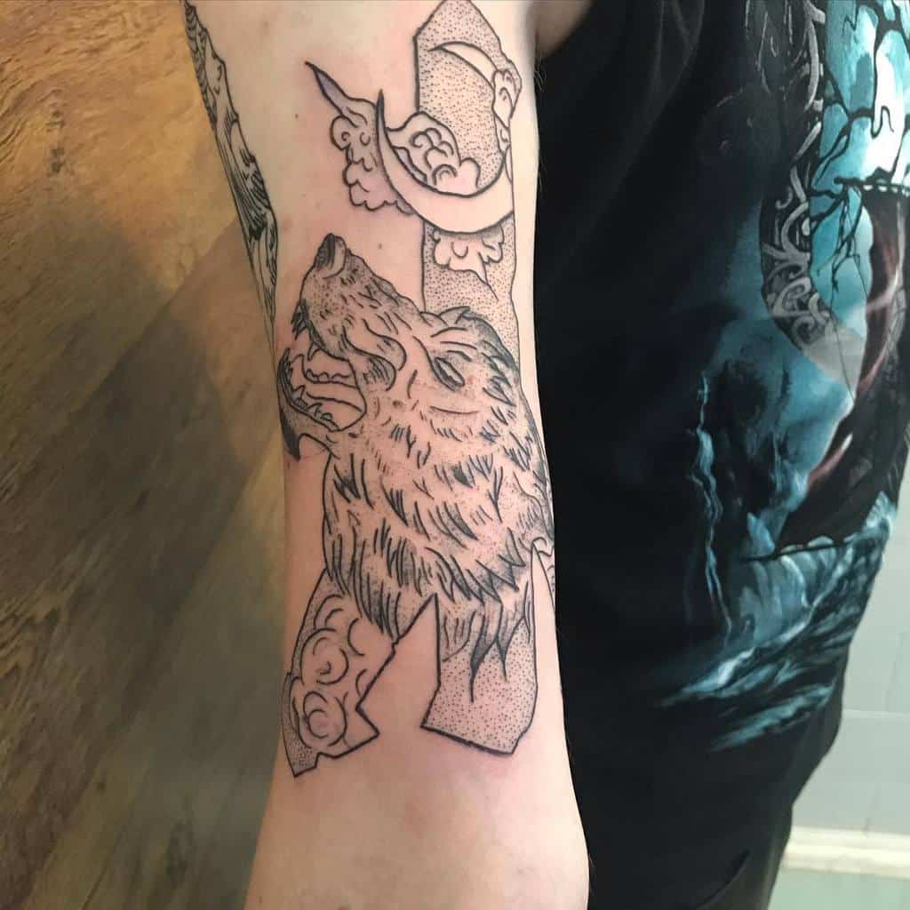 This tattoo combines Norse wolf symbolism with intricate dotwork patterns and decorative elements, creating a bold and meaningful design