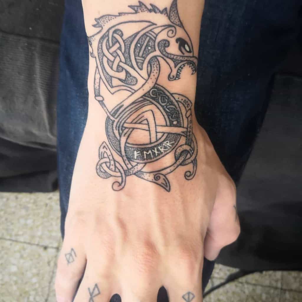 This tattoo combines Norse wolf symbolism with intricate dotwork patterns and decorative elements, creating a bold and meaningful design