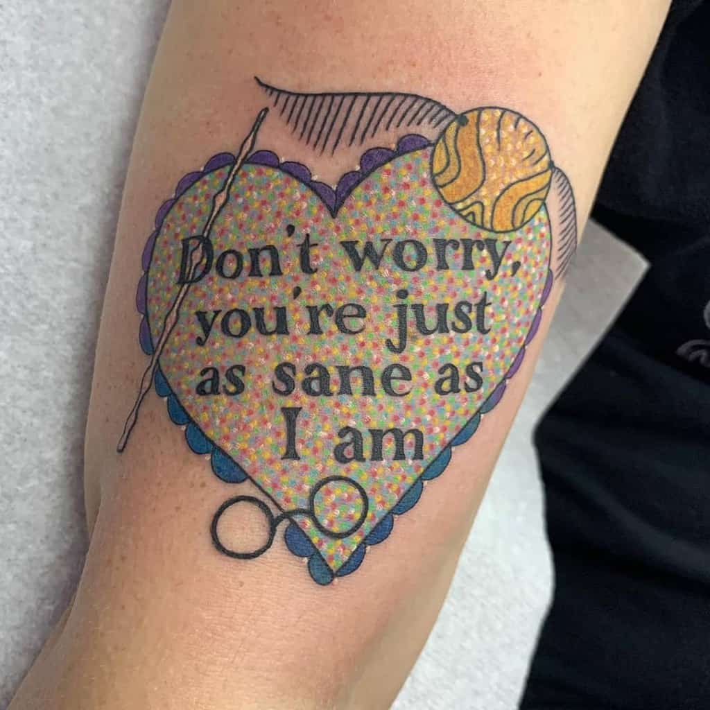 Harry Potter tattoo of Luna Lovegood’s quote: 'Don’t worry, you’re just as sane as I am,' inside a heart with a wand, Snitch, and Spectrespecs