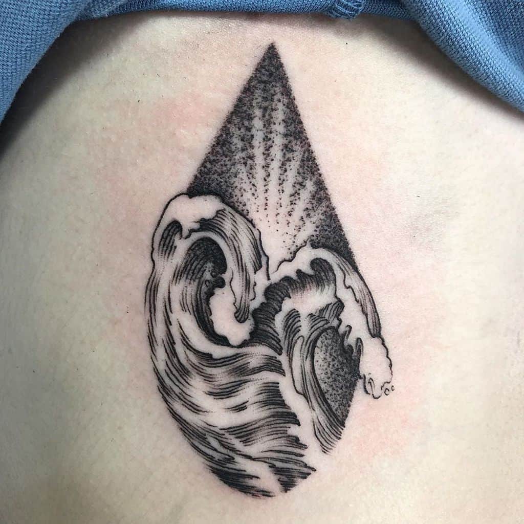 Black and grey tattoo featuring stylized ocean waves within a geometric drop shape, using fine linework and dot shading