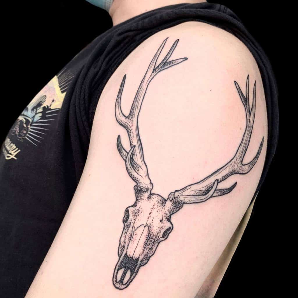 Tattoo of a majestic deer skull with antlers on a person's upper arm