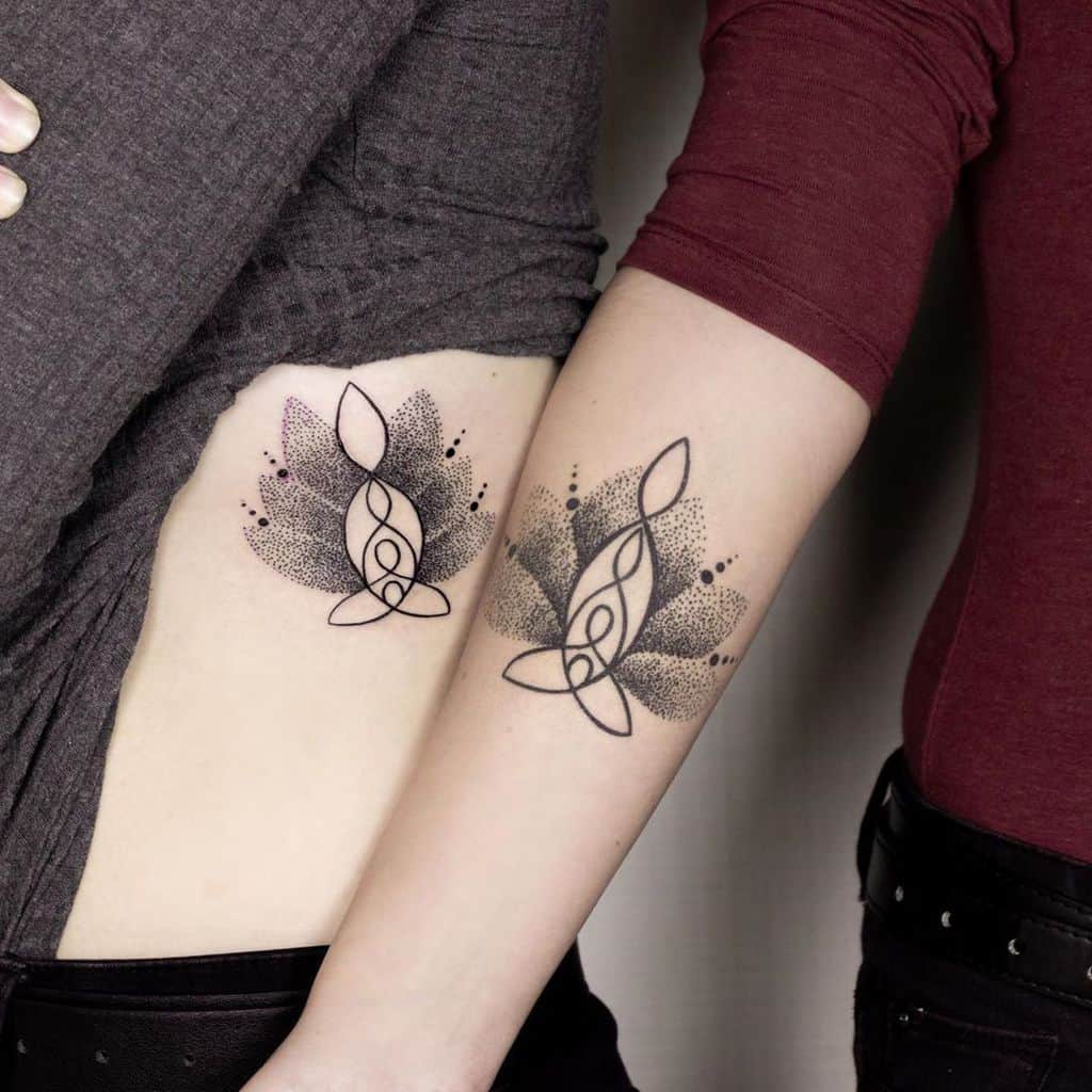 Matching sister tattoos featuring a treble clef intertwined with a Celtic knot, surrounded by dotwork wings