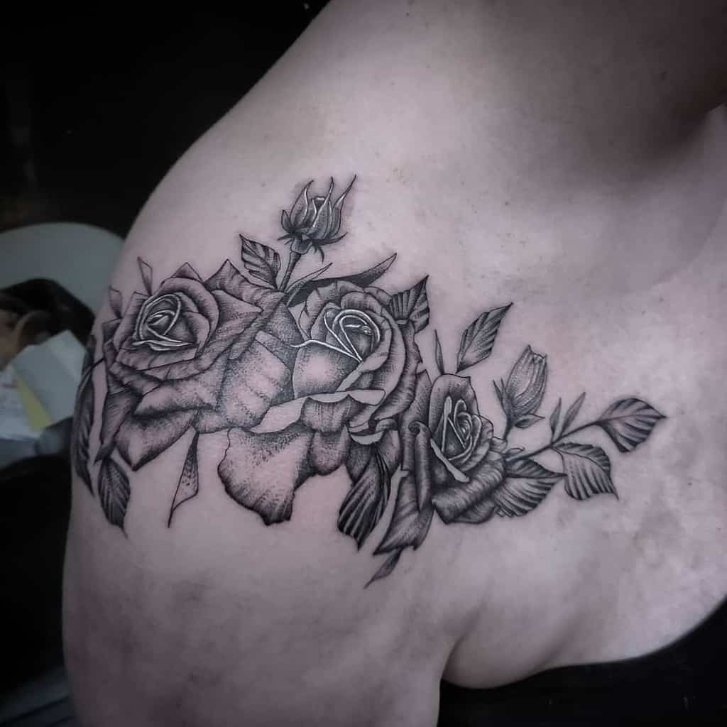 A stunning black and gray rose tattoo elegantly graces the shoulder, blending artistry with personal expression