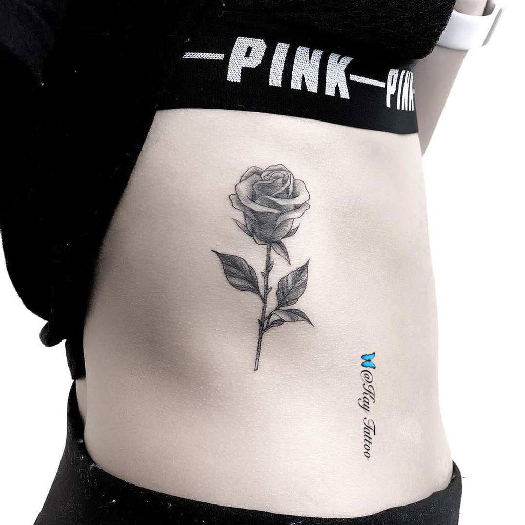 Black and gray rose tattoo on a woman's side