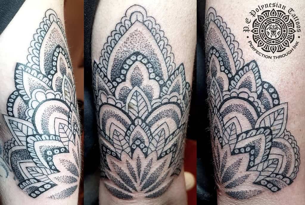 Mandala tattoo on upper arm with intricate geometric patterns and shading