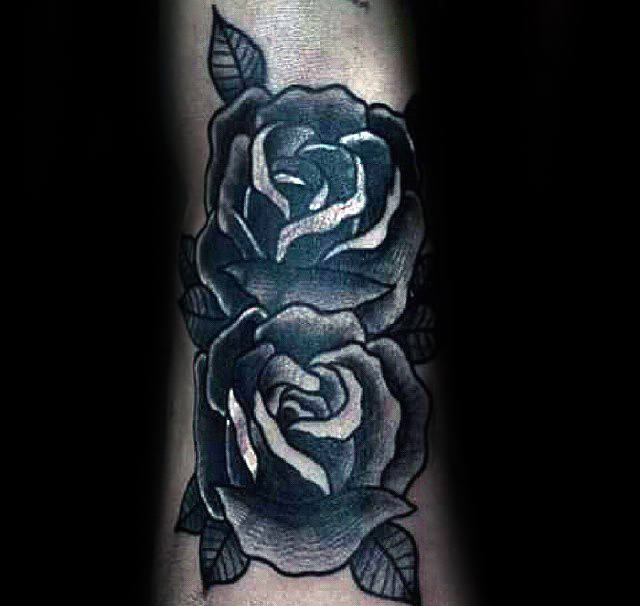 Tattoo of two black roses with leaves on a textured skin background