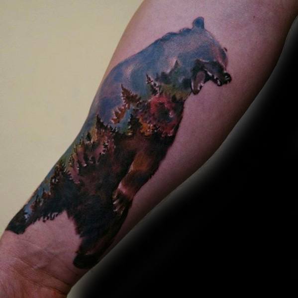 Realistic tattoo of a roaring bear silhouette filled with a scenic forest landscape and mountain elements, blending nature and strength.
