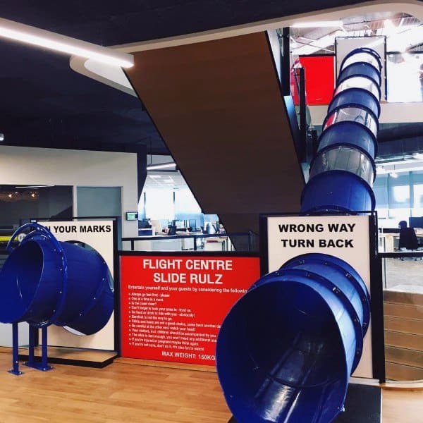 Slide into the office with signs reading "Flight Centre Slide Rulz" and "Wrong Way Turn Back