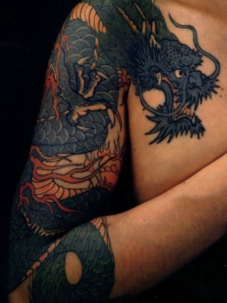 Colorful dragon tattoo covering a person's arm from shoulder to wrist