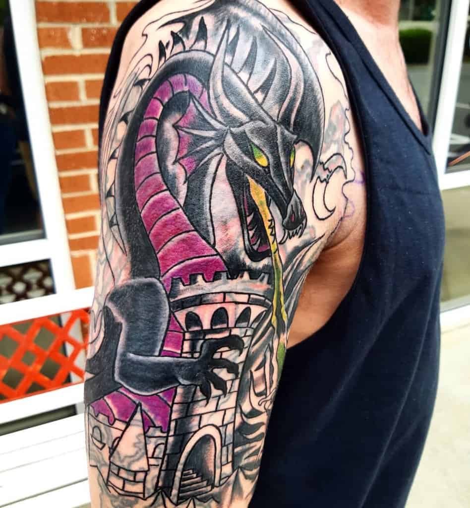 Tattoo of a Maleficent dragon with green eyes and purple scales, breathing fire above a castle on a man's upper arm