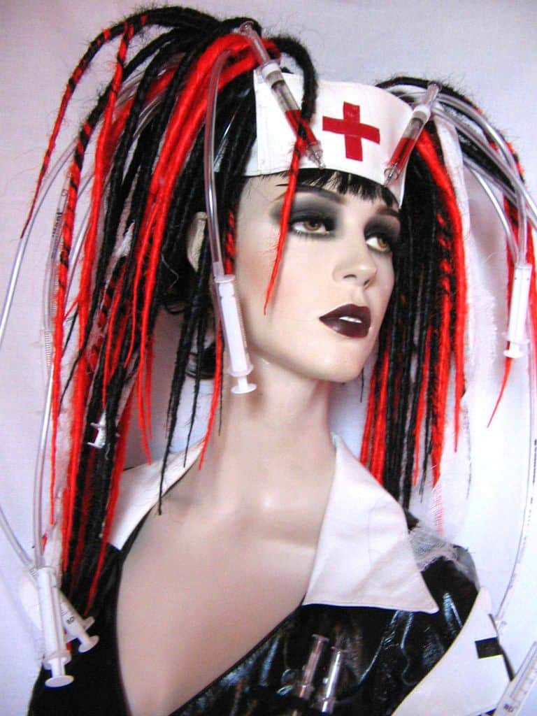 A cyberpunk hairstyle for women with dreadlocks and medical supplies attached to different dreads