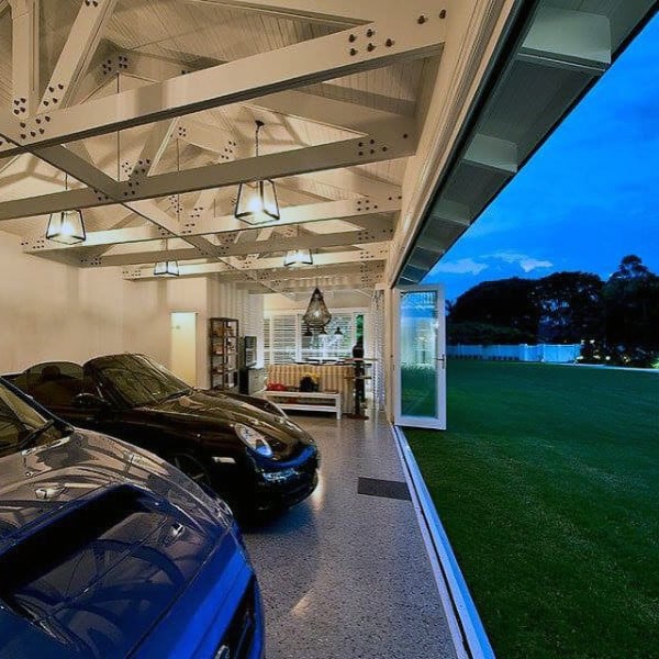 A luxurious open-concept garage with elegant lighting, polished flooring, and scenic outdoor views.
