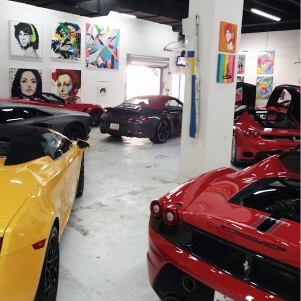 A vibrant garage featuring luxury cars surrounded by colorful pop art displayed on the walls, creating an artistic and stylish atmosphere.